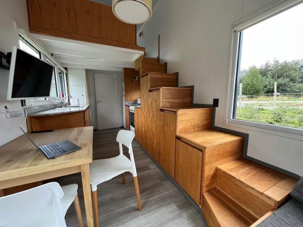 Mesa con computadora junto a la escalera de madera