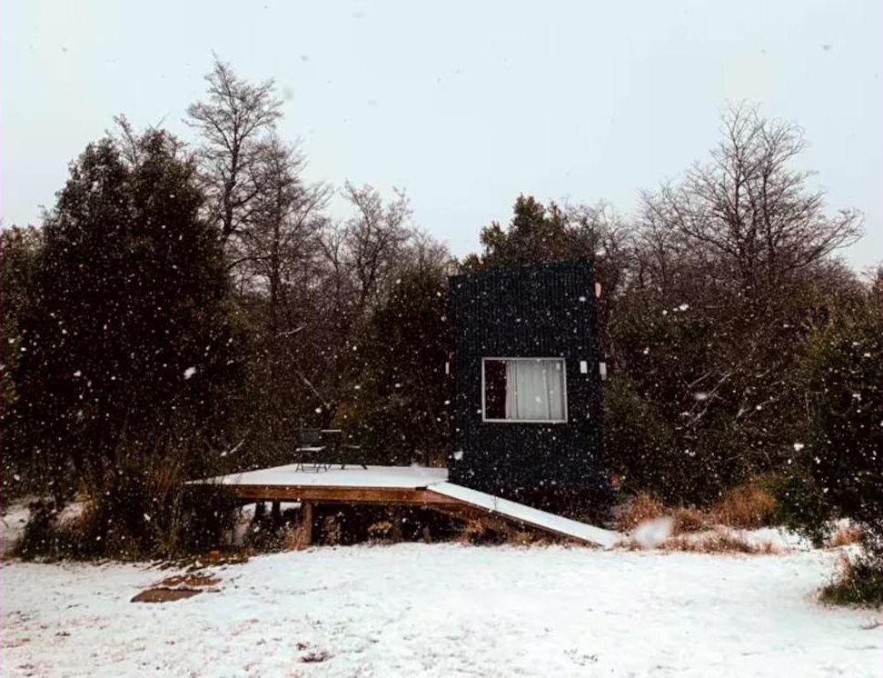 Tiny house con la nieve cayendo en invierno